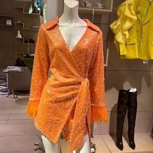 Orange sequin wrap dress with feather trim sleeves.